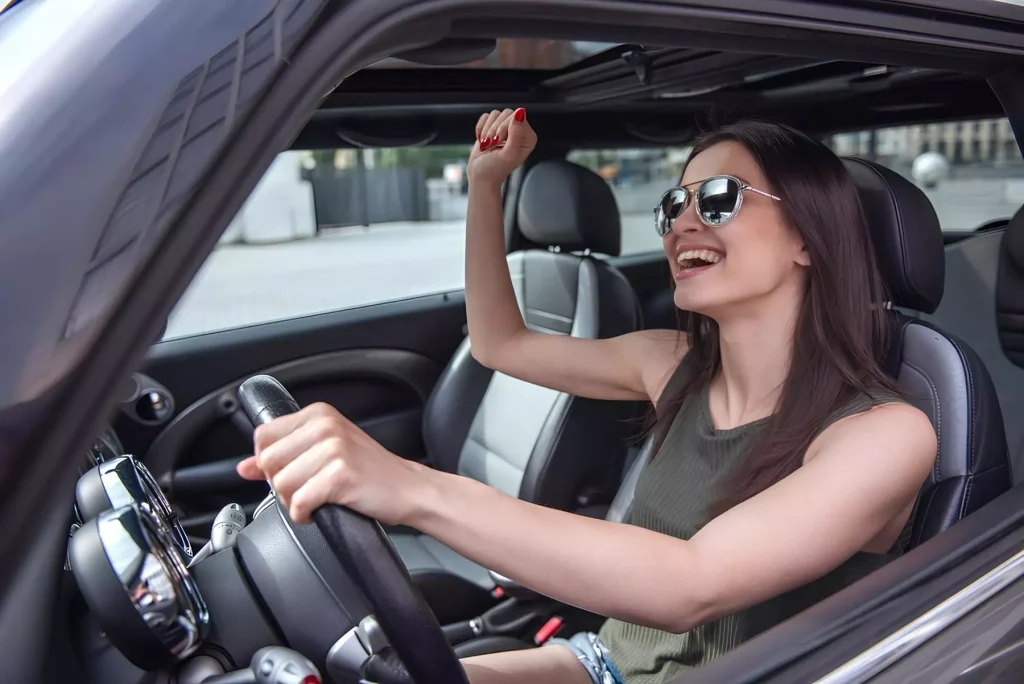 Woman Driving Car Smiling and Enjoying On-Demand Rideshare Car Rental